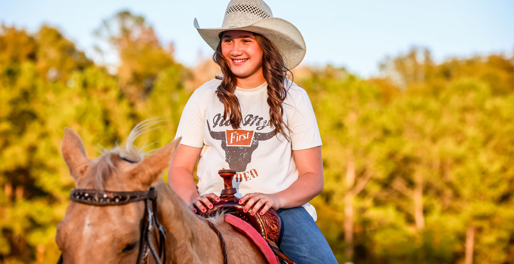 Ella Nipper sitting on her horse smiling.